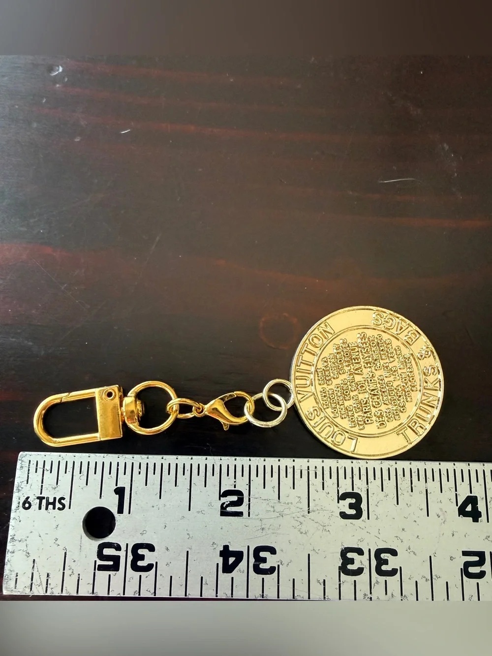 LV gold tone “trunks & bags” bag charm on a new Lobster claw swivel hook. GUC